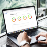Laptop on table by window SmartCerdit website showing using ScoreTracker tool